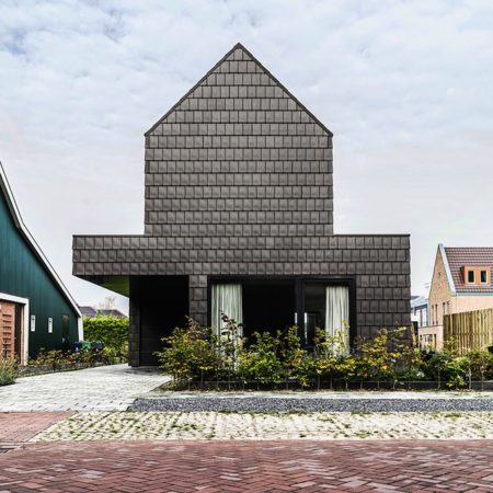 Anthracite ceramic tiles help protect the privacy of the family living in the V House in the Netherlands while giving the home a sense of grandeur.